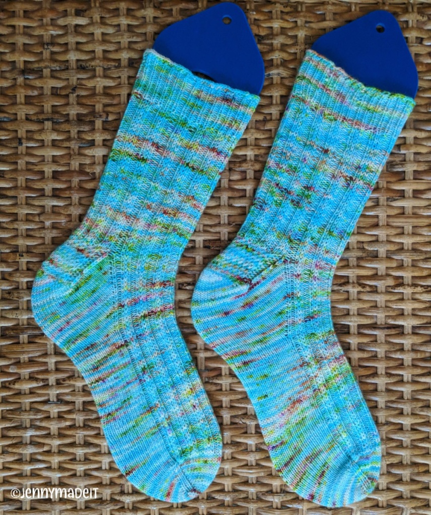 This is a photo of two knitted socks on blocking forms. 