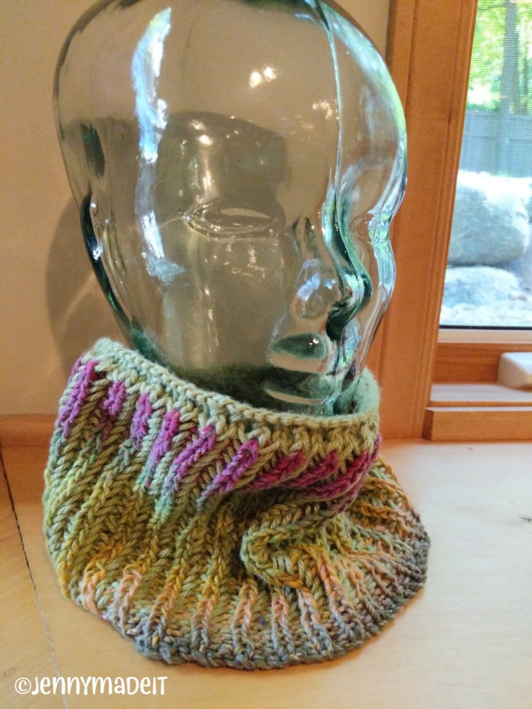This is a photo of a glass head displaying a knit neck warmer I made.